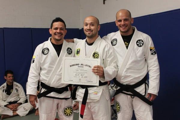 Higher Ground instructor, Sean Fernandez receiving his black belt from Xande & Saulo Ribeiro.