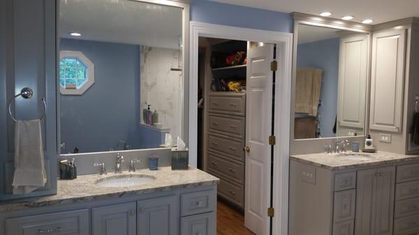 Matching vanities flank the door from the closet.  The tower storage and framed mirrors give for a clean look...