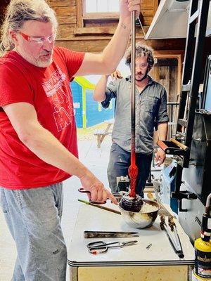 Spencer and his assistant shaping a glass pumpkin