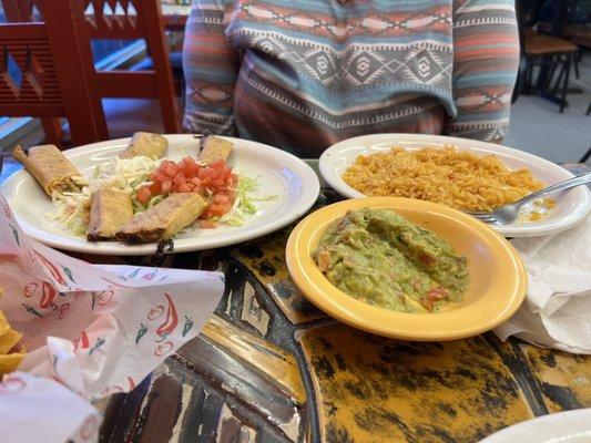 Chicken Flautas with rice and a side of guacamole.