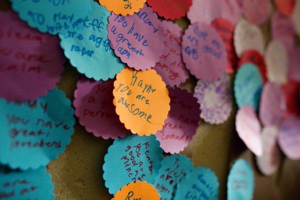 School-agers filling a wall of compliments.