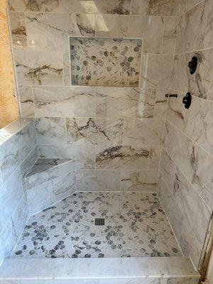 Beautiful marble shower with corner bench!