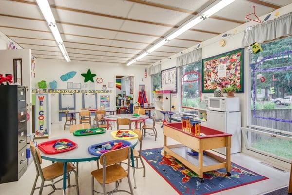 The main classroom where kids enjoy open play with arts and crafts, playdough, dress up, fine motor control activities.