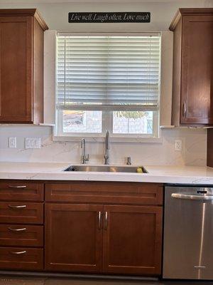 Kitchen counter and backsplash - stone going up both sides of window