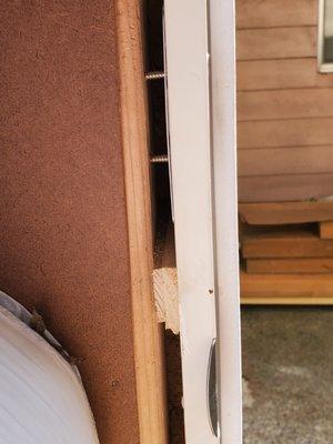 The installers used wood chips, etc. to keep the door in. Notice the screws which are exposed because the frame was improperly construction.