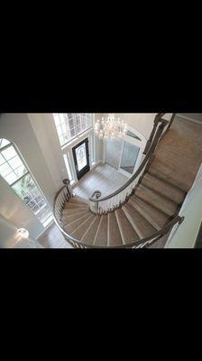 This entry has a new life with beautiful taupe carpet, crystal chandelier, and restrained rails in a grey wash