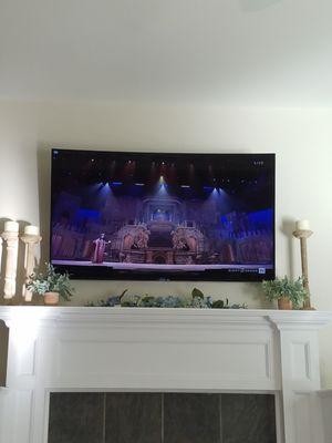 Samsung television mounted over fireplace as part of surround sound system