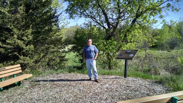 Dale Cox, son of Bill & Margaret, standing between their benches at the tip of Clitty Lake.