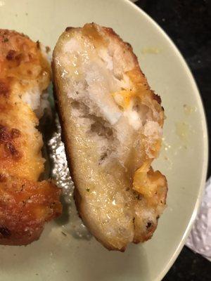 Stuffed cheesy breadstick side view. The entire bottom half is just grease and oil.