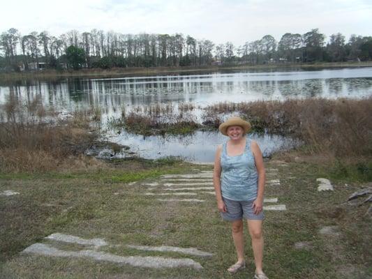 Scruffy person in front of scruffy lake