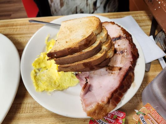 Scrambled eggs, ham and sour dough toast.