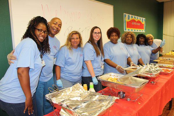 Staff serving food at an event pose for the camera.