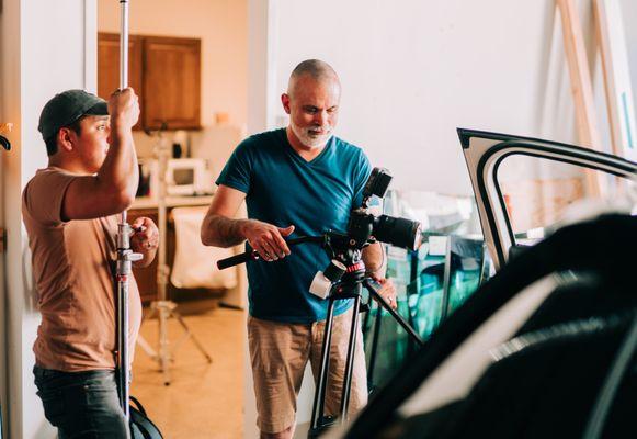 Two video marketers for Oneupweb adjust equipment while creating brand photography and videography for a client.