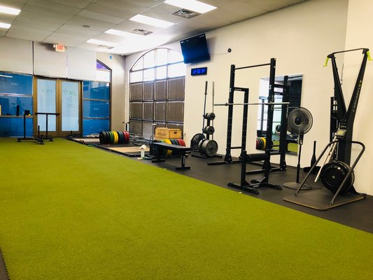 Free weights, lifting platforms and racks, sleds, athletic turf, open space.