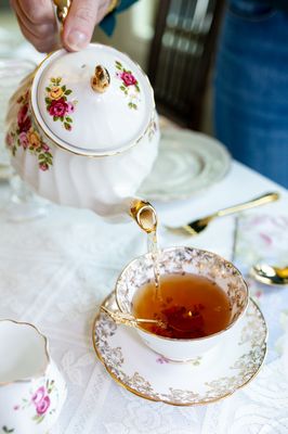 Vintage teapot pouring tea in beautiful teacup during tea party in Wake Forest