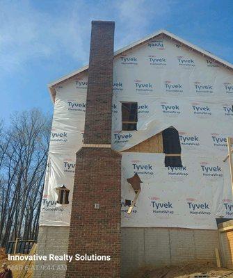 A gorgeous masonry fireplace and chimney on a new home