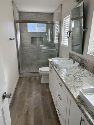 Updated cabinets, counters, flooring, vanity, mirrors, shower stall and hand set tile mosaic