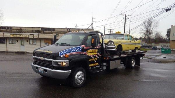 Towing away yellow cab staple that was parked on corner of yellow cab for many years.Company was sold. Part of history and towing a classic.