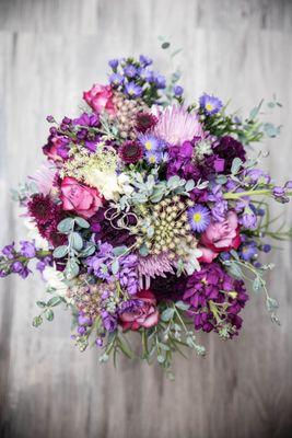 Bridal bouquet in shades of purple and greenery accent.