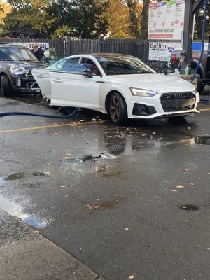 Car getting vacuumed before going into the wash bay