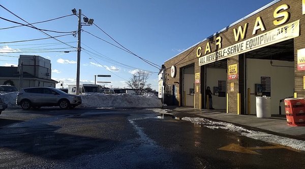 Car wash bays in front of automatic car wash tunnel.