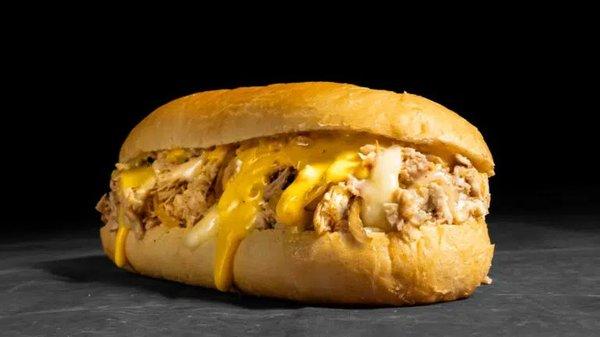 Chicken Cheesesteak: Thinly sliced chicken, melted provolone, cheddar sauce, griddled onions on a toasted hoagie roll