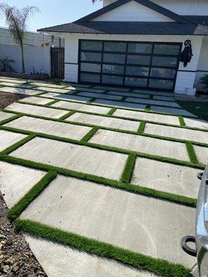 Concrete squares pour in place with artificial grass in between.