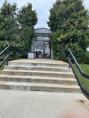 After 10 minutes of driving around the lot and calling twice I saw people carrying stuff down these stairs.