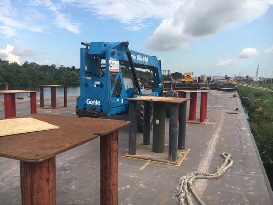 Fork lift moving stands on the deck of a barge