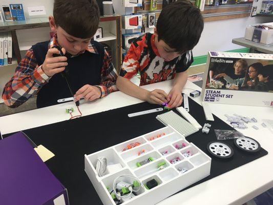 Two of our students enjoying littleBits, a product we sell and love to teach! It helps students learn about electricity & making inventions!