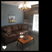 Farm House Suite living area, complete with a queen sofa sleeper and barn wood walls.