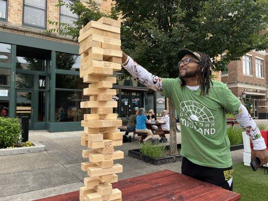 A man plays Giant Jenga during an Adult Recess session, a free weekly event for adults from 11:30 a.m. - 1 p.m. on Wednesdays all summer