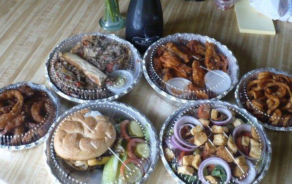 Take-out during the quarantine: Cheeseburger, cheesesteak, wings, curly fries, onion rings, salad, and a bottle of Prosecco.