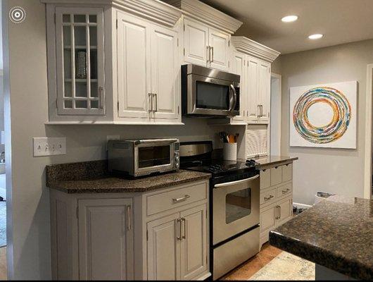 After: Off white paint color on upper cabinets with a medium grey color on the lower cabinets and new hardware