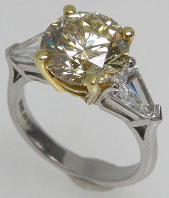 4.64ct Fancy intense yellow/ VVS2 Diamond -round shape set in a platinum ring with 2 shield diamonds on the sides.