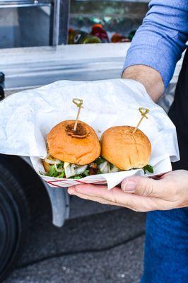 Crab Cake Sliders - Hand made lump crab cakes over dijon aioli, topped with Old Bay pickled onion, and arugula