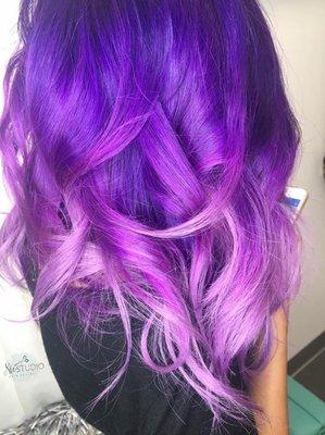 Balayage ombré is transitioning of dark purple, medium to light pastel purple.