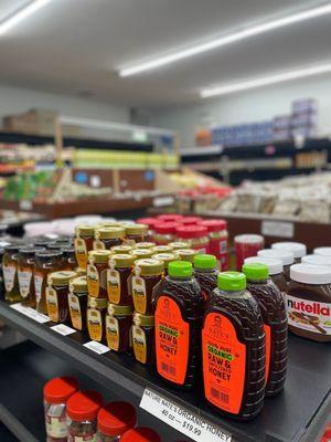 Anmol Meat and Grocery's table displaying various brands of honey.