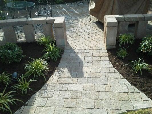 A paver patio with sitting wall installed at a residence in Paris, TN. by Lawnmasters Lawn and Landscape