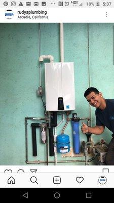 One of the third generation plumbers servicing a tankless water heater! Cool shot Juanito!