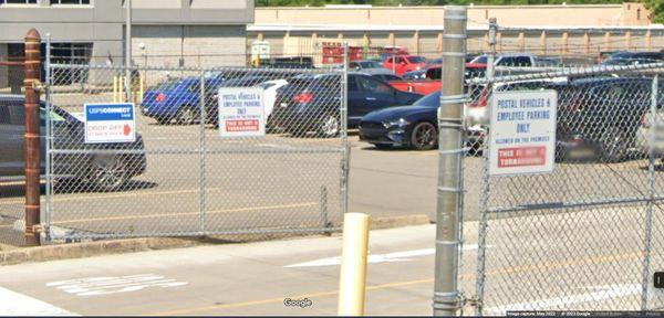 The sign directing business customers to the back loading dock area where, as the sign next to it states non-USPS entities cannot go.