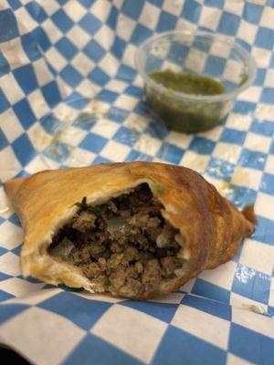 Inside of beef sambusa with green salsa hot sauce