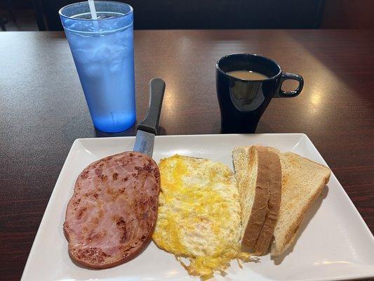 Two eggs over hard, ham, sourdough toast.