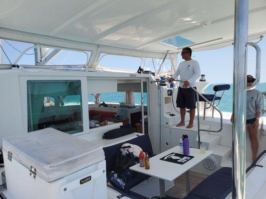 Captain Brad and First Mate Leilani at the helm and in the cockpit of the Aria, a 42 foot catamaran!