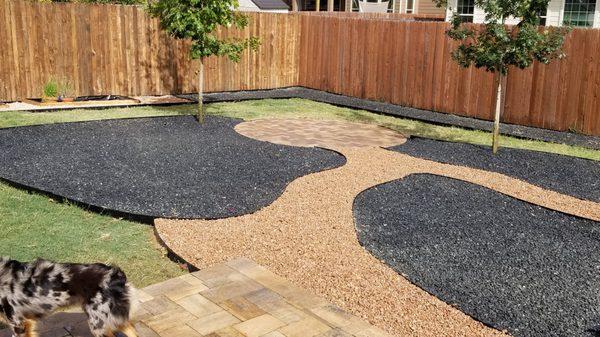 Black garden beds, brown pathways and an informal patio. Two red oak trees. They did a good job of matching the pavers with our deck pavers.