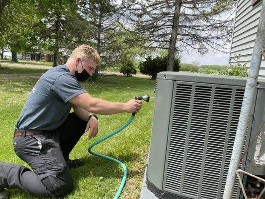 Kalim performing an air conditioner tune up. With dirt being the number one reason for A/C repairs. It's important to keep them clean.