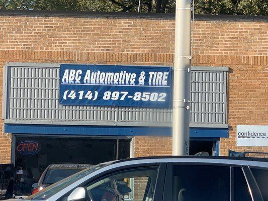 The repair shops business sign printed on a IRC's of vinyl and screwed onto the wall.