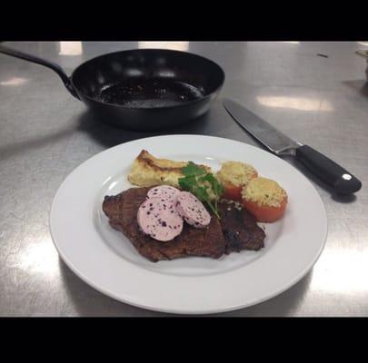 14oz Ribeye steak topped with red wine shallot butter stuffed tomatoes and scallop potatoes as sides