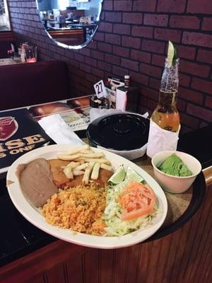 Corona, fried fish, rice, salad, french fried and fried beans.