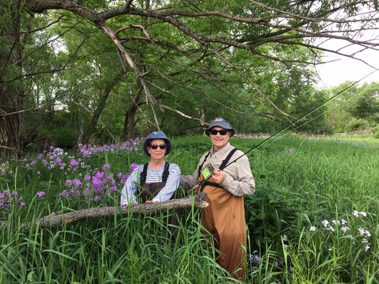 A happy couple poses in a field of flowers.